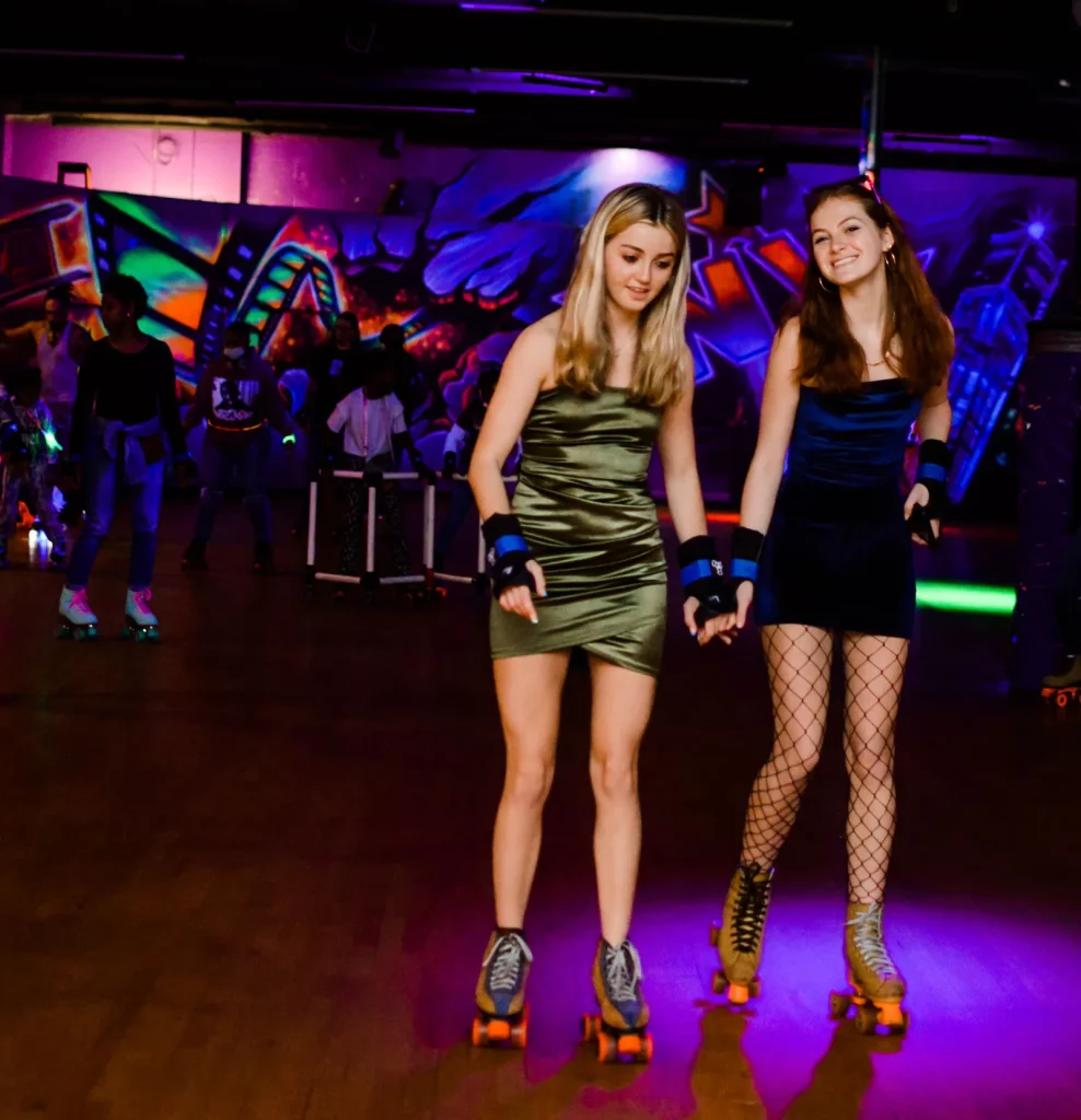 two teen age girls skating and smiling