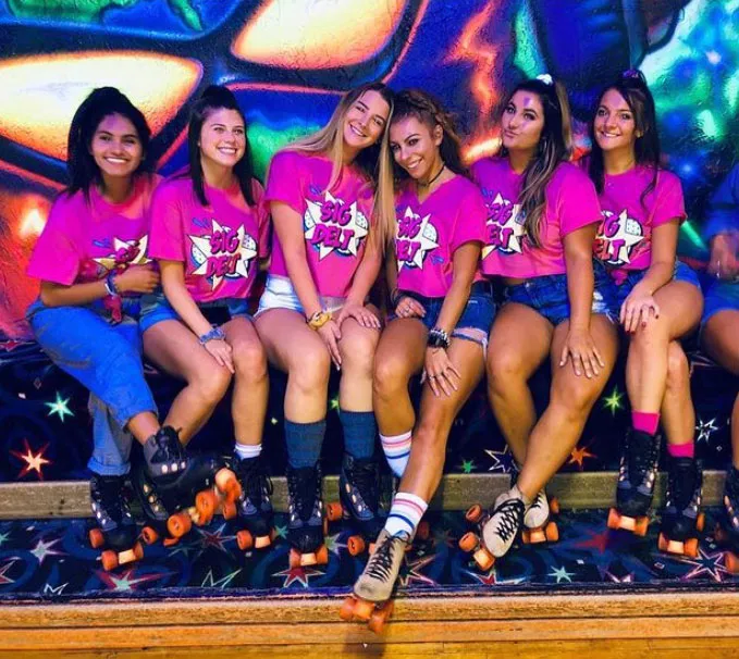 six sorority girls sitting with skates on