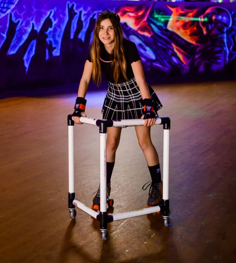 girl using a skate mate to help her roller skate without falling