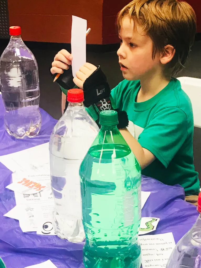 boy liter bottles for a STEM project