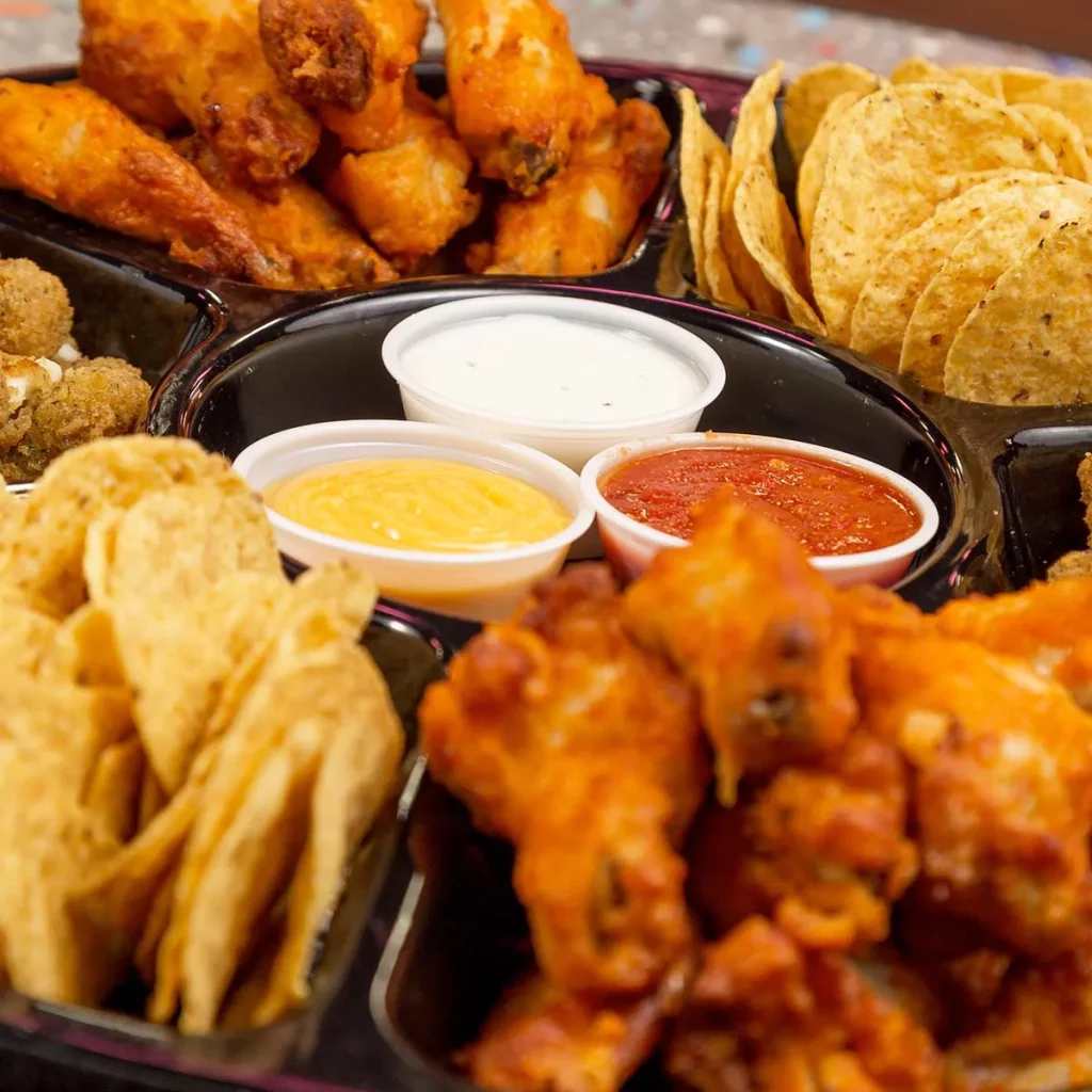 platter of wings, nachos and dipping sauce