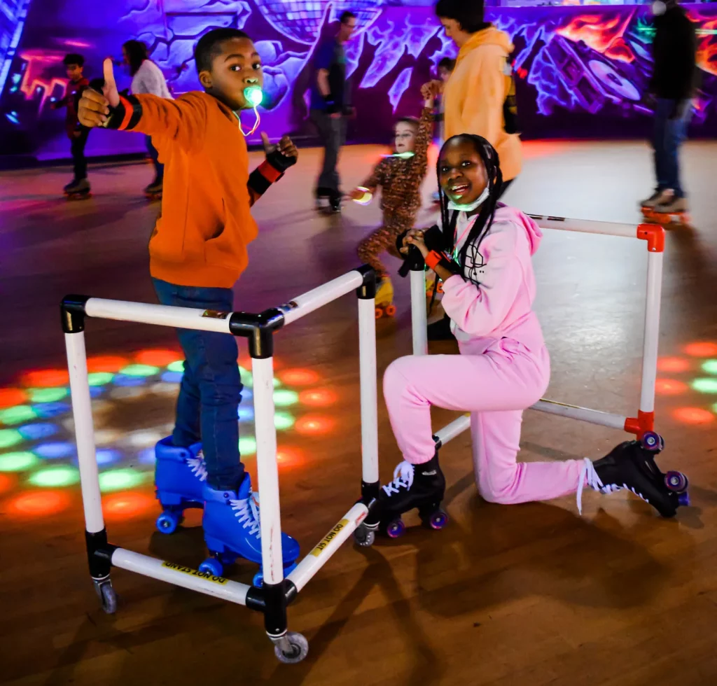 two kids skating and giving thumbs up