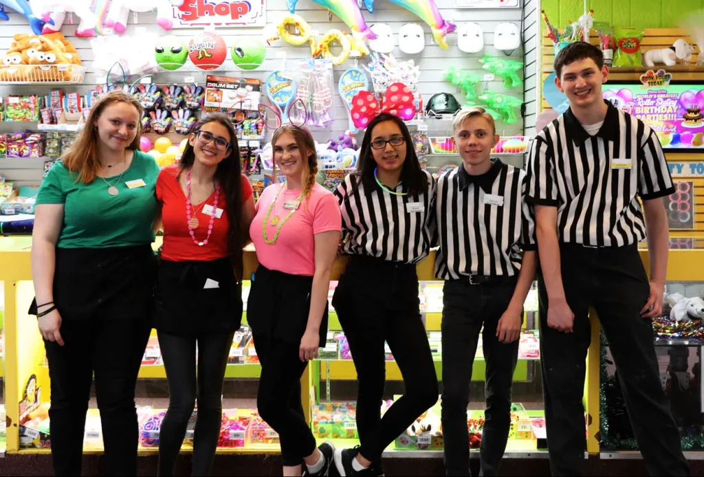 six employees, 4 women, and 2 men standing in front of the prize redemption counter