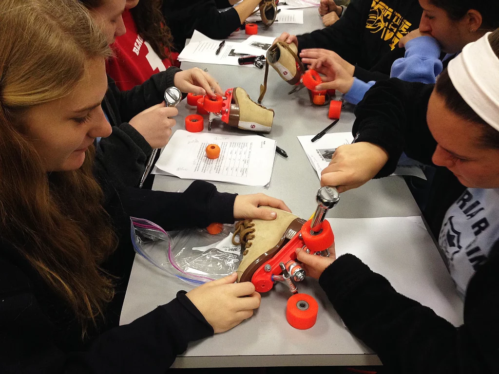 Two girls working on a STEM project with roller skates during a school field trip