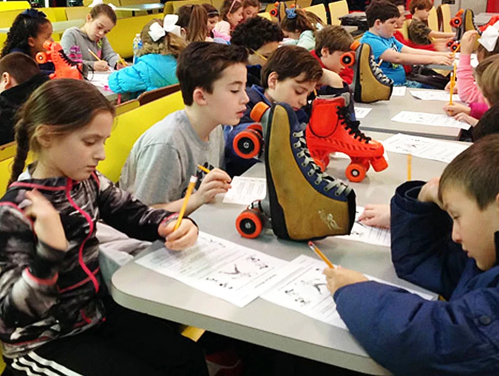 Large group of school kids learning about roller skates and STEM projects