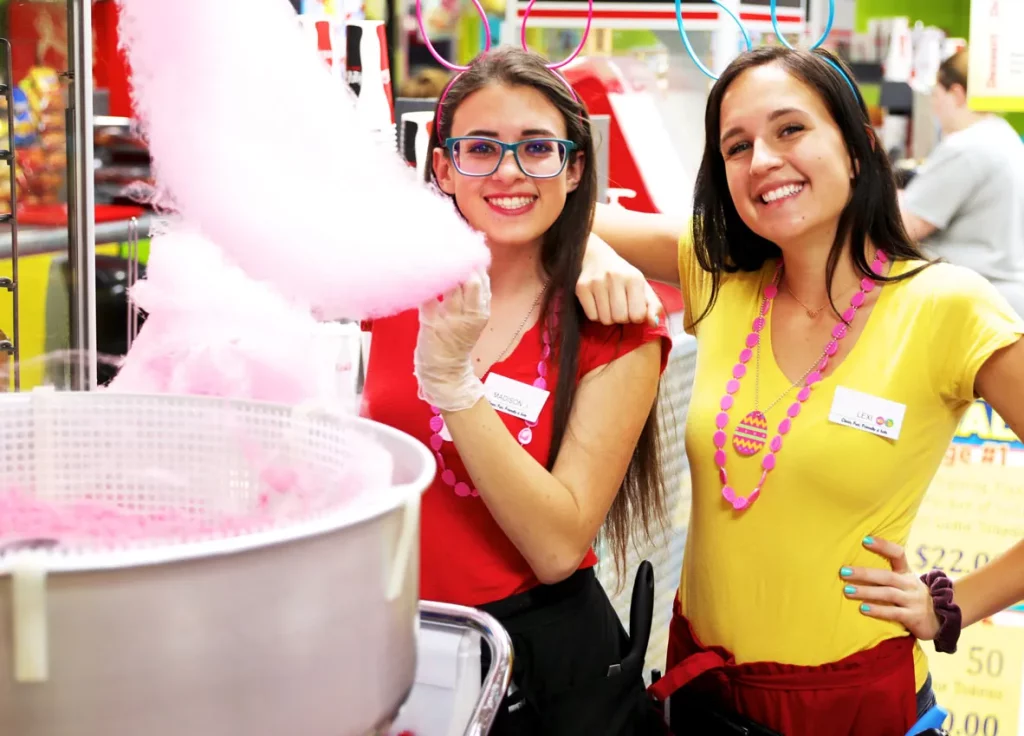 two female staff members making cotton candy